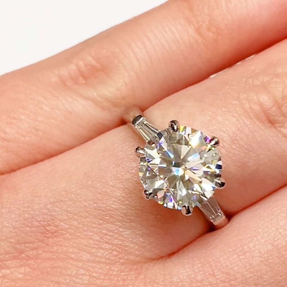 Featuring a Brilliant cut solitaire diamond 2 tapered baguette cut diamonds that frame the stunning centre stone as it deserves.