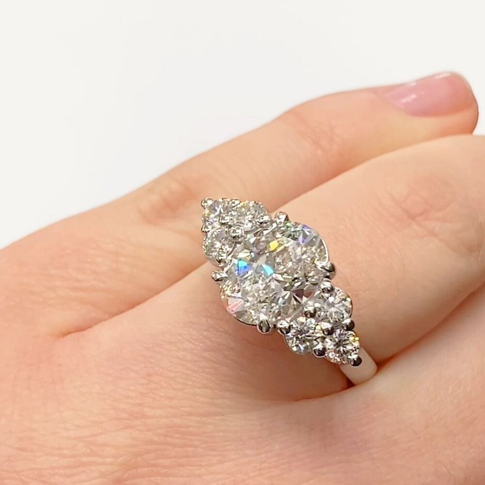 Oval diamond cluster with upswept rail ring